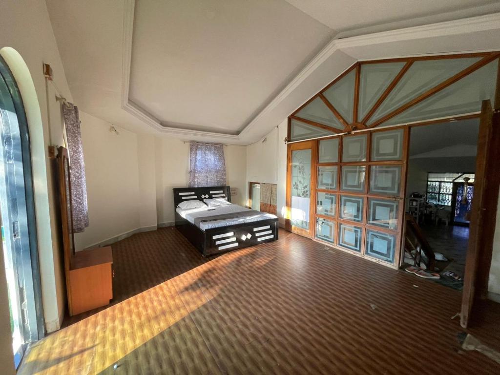 ein Zimmer mit einem Bett in der Mitte eines Zimmers in der Unterkunft OTE Dulis Den in Pune