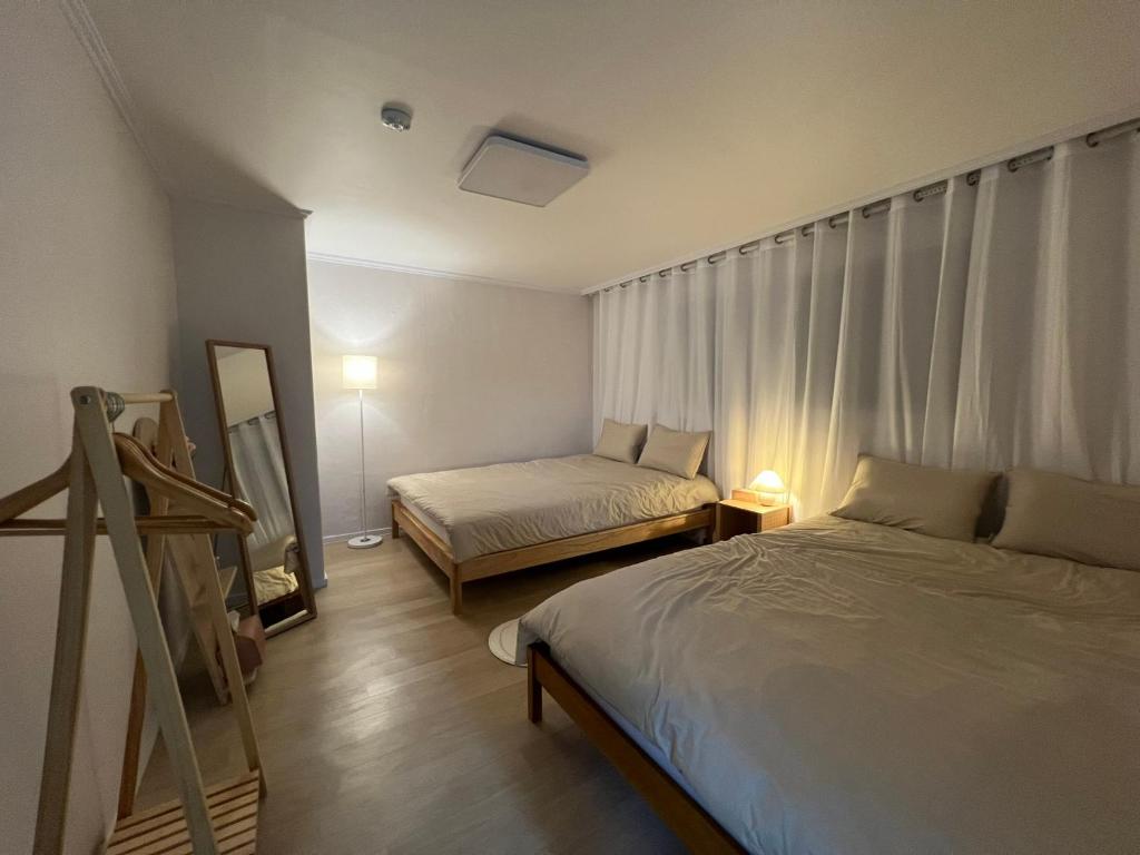 1 dormitorio con 2 camas, espejo y escalera en Gongdeok Stay, en Seúl