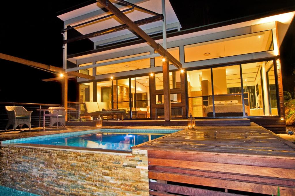 a swimming pool in front of a house at night at Crystal Creek Rainforest Retreat in Crystal Creek