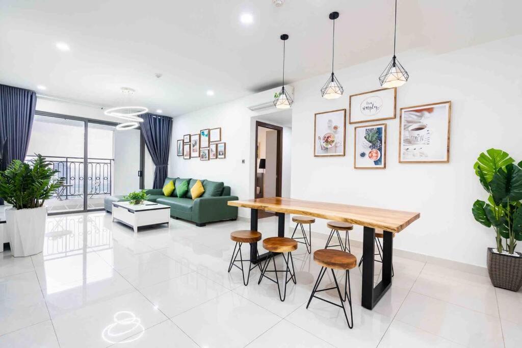 - une cuisine et un salon avec une table en bois et des tabourets dans l'établissement 3Br-Saigon Royal-30 Fl-Hana Apart-3014, à Hô-Chi-Minh-Ville