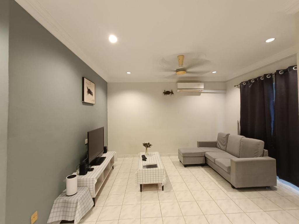Tambun Sunway Homestay في تامبون: غرفة معيشة مع أريكة وتلفزيون