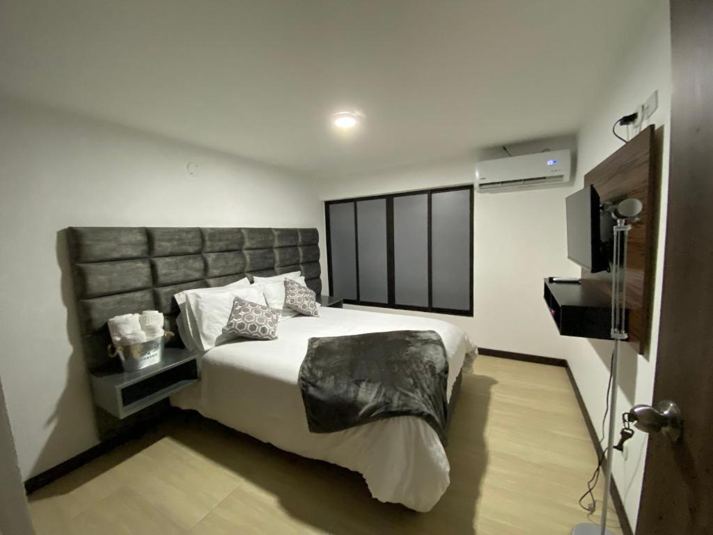 una camera con un grande letto e una televisione di Beauté a Pereira