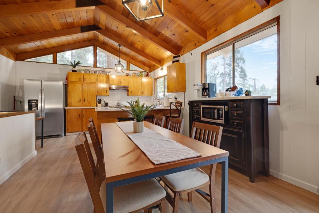uma cozinha e sala de jantar com mesa e cadeiras em Álaínn Cabin in the trees em Twain Harte
