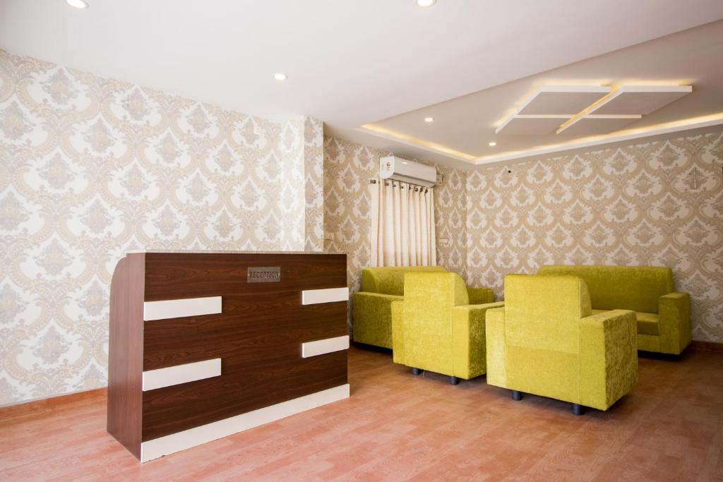 een wachtkamer met gele stoelen en een dressoir bij Pearl Suites - Located at a strategic location where Srinivasa Sethu Flyover starts and only hotel in the area to have a very spacious car parking - Skip city traffic to reach Main Temples and Airport - AC Rooms, Family Suites, Fast WiFi in Tirupati