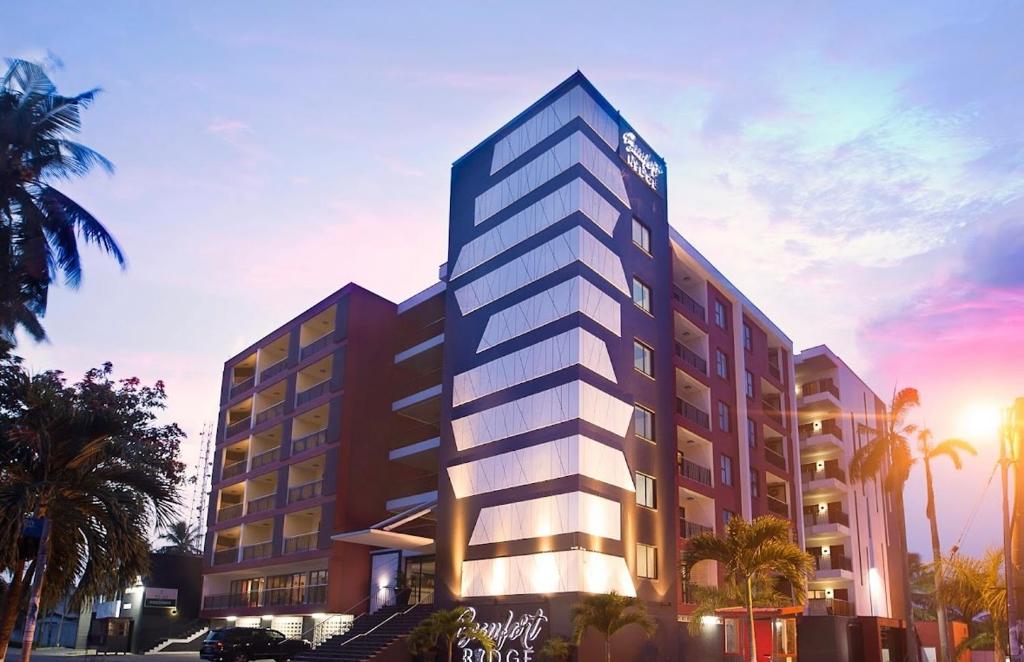 阿克拉的住宿－Beaufort Ridge Apartments Accra，棕榈树高大的建筑的 ⁇ 染