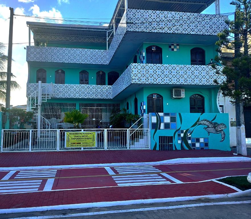 un edificio blu con un murale sul lato di Residencialpinheiro (apto 2) a Porto De Galinhas