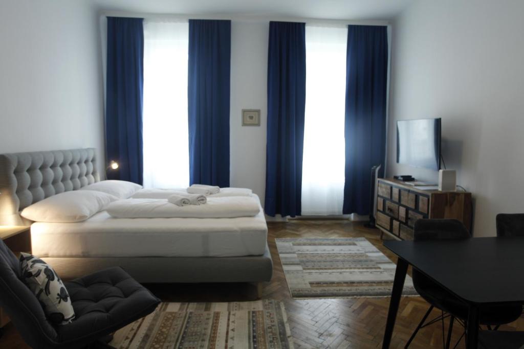 um quarto com uma cama, uma mesa e uma televisão em Casa Nostra - Schöne 3-Zimmerwohnung am Augarten em Viena