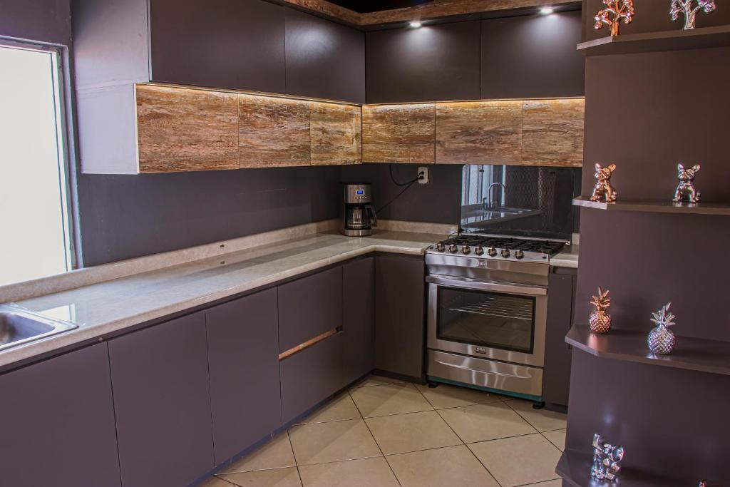 a kitchen with gray cabinets and a stove top oven at Casa Luna in Quetzaltenango