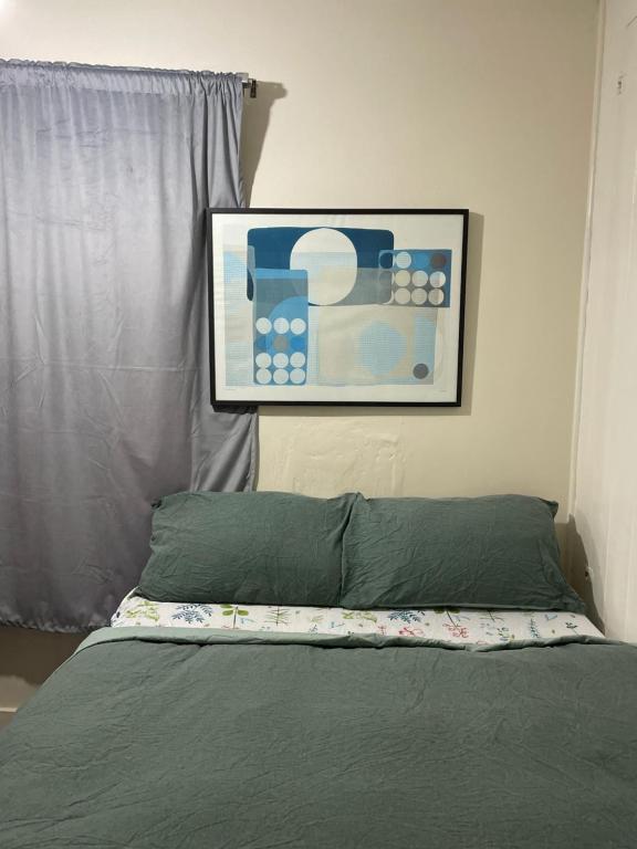 a bedroom with a bed with a picture on the wall at Stay with Light in Ipswich