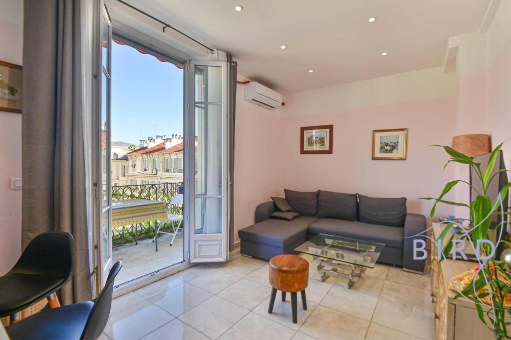 un salon avec un canapé et une grande fenêtre dans l'établissement Bright apartment in the Heart of Nice, à Nice