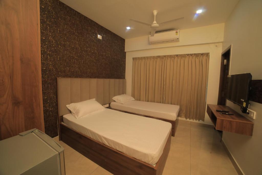 a hotel room with two beds and a television at K LUXURY INN in Chennai