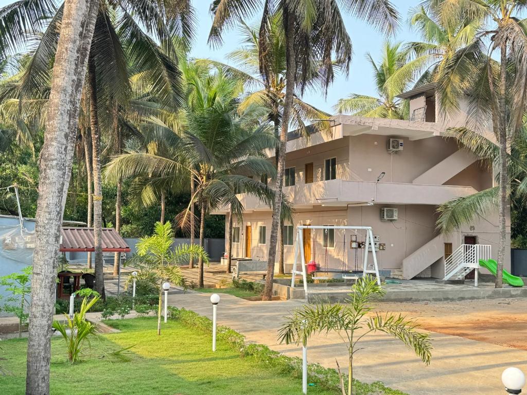 a house with palm trees in front of it at The Saltwater Home stay in Udupi