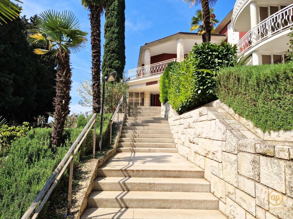 Un escalier mène à une maison avec des palmiers. dans l'établissement San Lorenzo Apartment, à Portorož