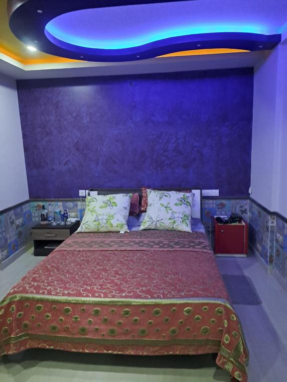 - une chambre avec un grand lit et un mur bleu dans l'établissement Galeela apartment Cochin, à Cochin