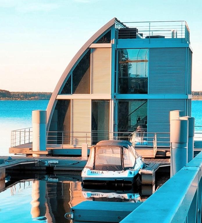 a house on a dock with a boat in the water at Ferienhaus "Silent" Grundbelegung 2 Pers in Elsterheide