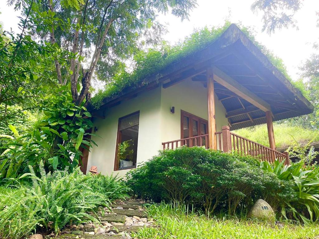 una pequeña casa con techo de hierba en BaHo Eco Beat en Ninh Hòa