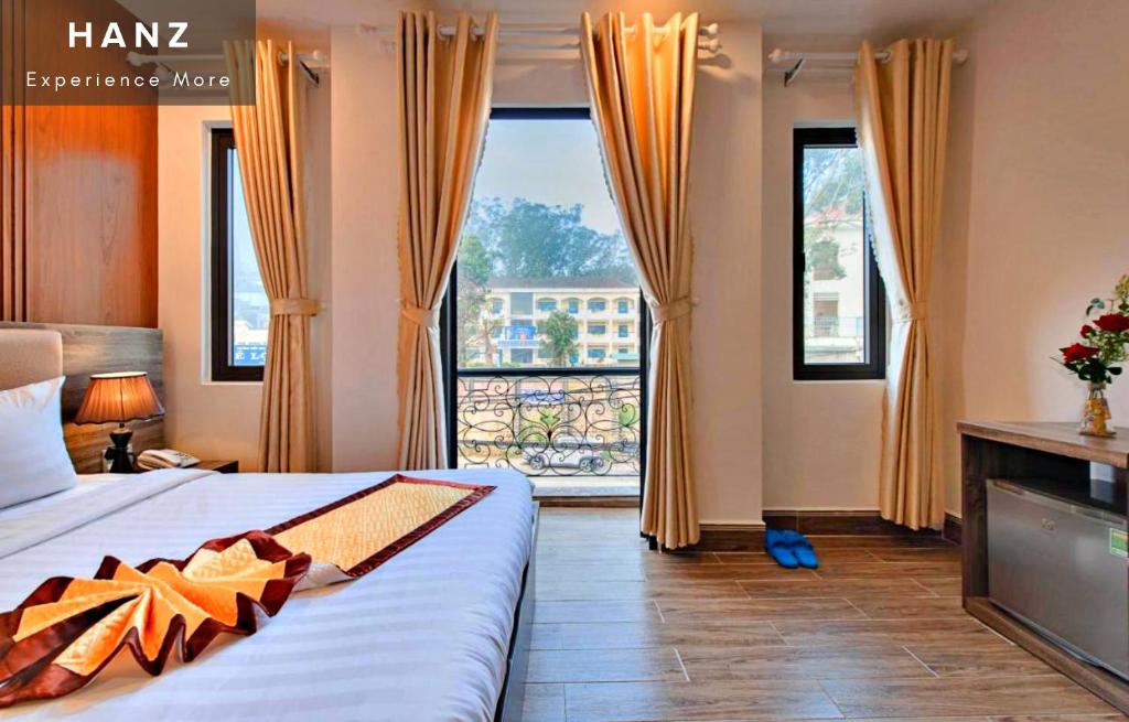 um quarto de hotel com uma cama e uma grande janela em HANZ Gia Hoang Hotel em Da Lat