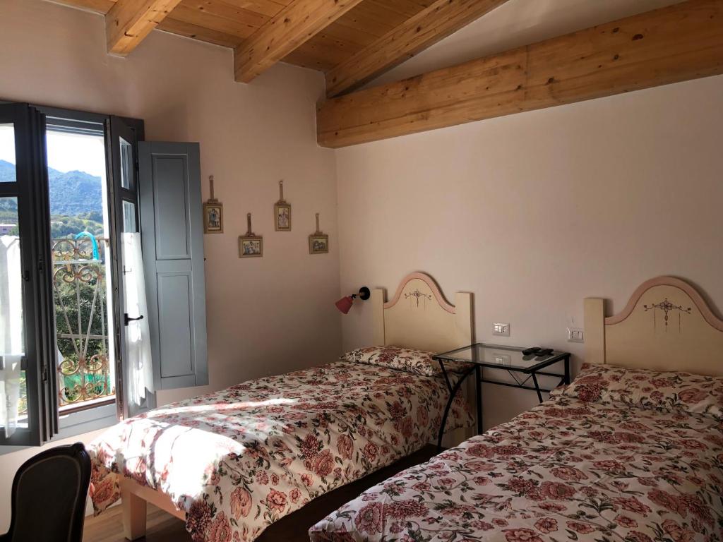 two beds in a room with a window at Agriturismo La Casa delle Fate in Loiri