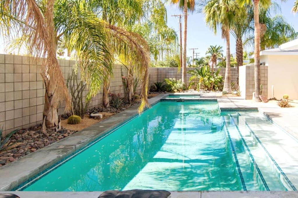 uma piscina num quintal com palmeiras em Luxury Oasis 1 - Entire 1 Bedroom Apartment in Abuja with Pool, Games, WiFi, Balcony, and Garden em Abuja