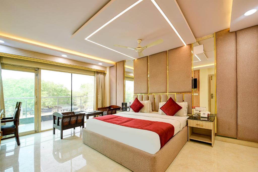 Schlafzimmer mit einem Bett, einem Schreibtisch und einem Fenster in der Unterkunft Staybook South Delhi in Neu-Delhi