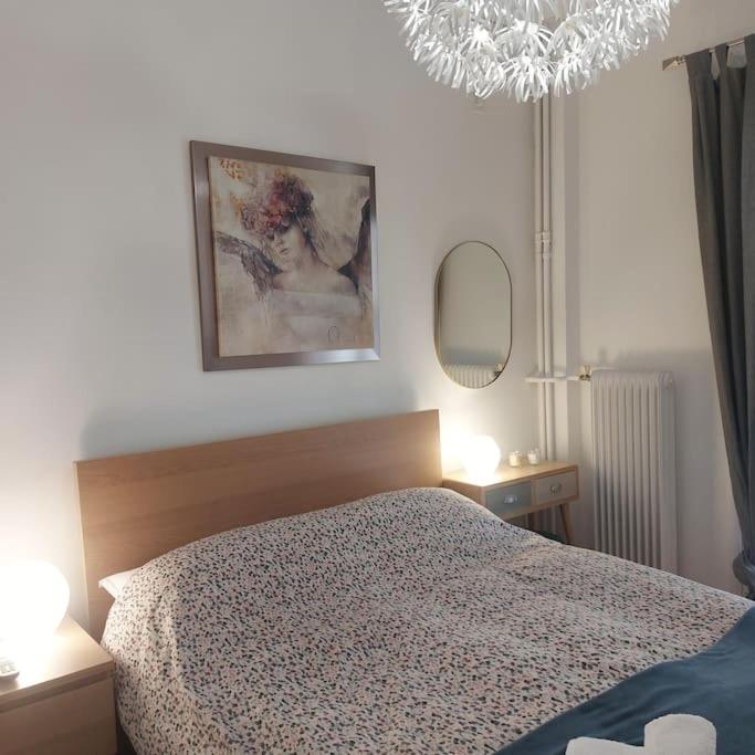 1 dormitorio con 1 cama, 2 lámparas y espejo en Flat in King's George B' Street en Pireo