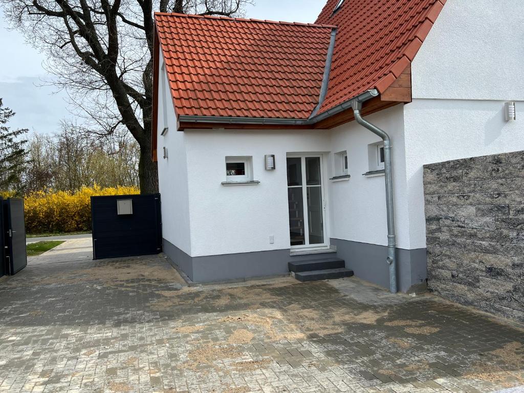 une petite maison blanche avec un toit rouge dans l'établissement Ferienhaus Constanze Mücheln am Geiseltalsee Maisonette Appartement, à Stöbnitz