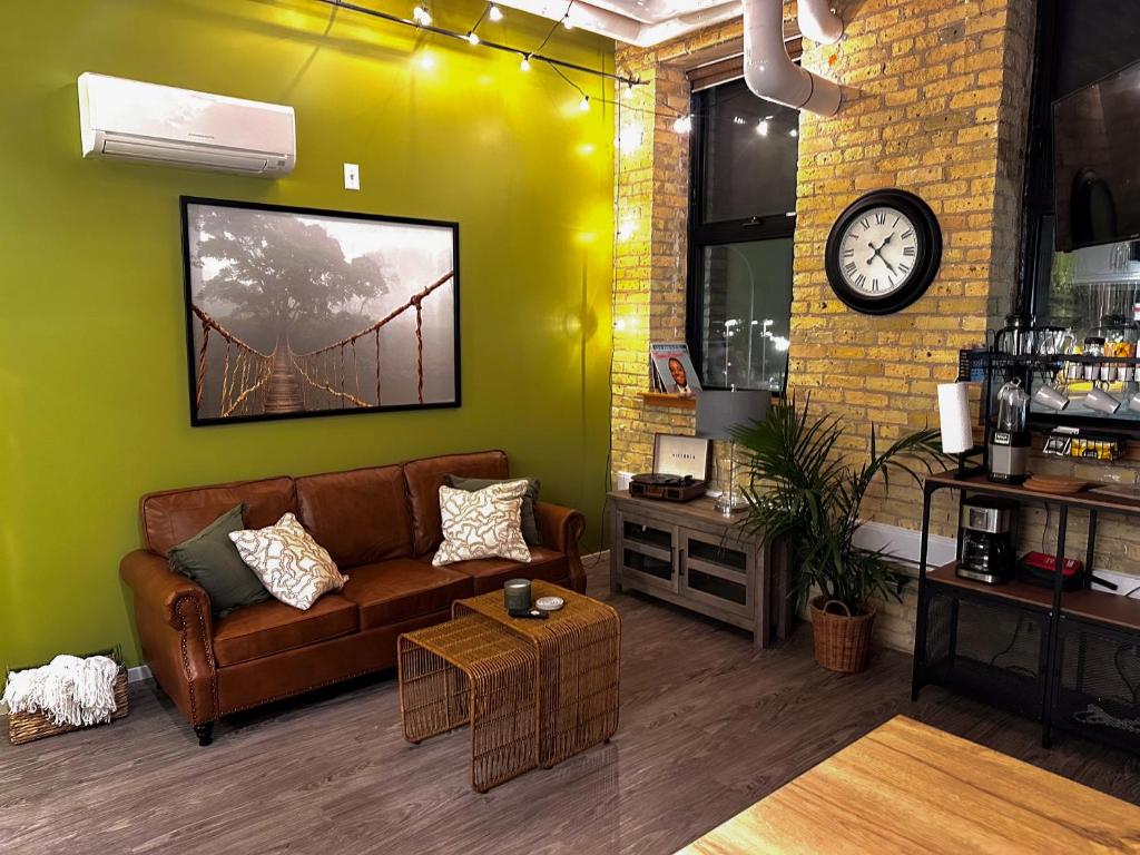 sala de estar con sofá y reloj en Heart of the City: Cozy 2-Bed Loft, en Winnipeg