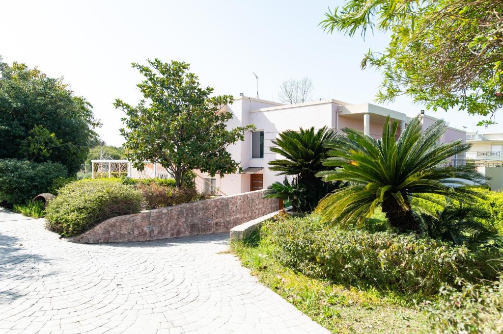 a white house with trees and a walkway at Kos Dream Beachwalk Apartment in Tigaki