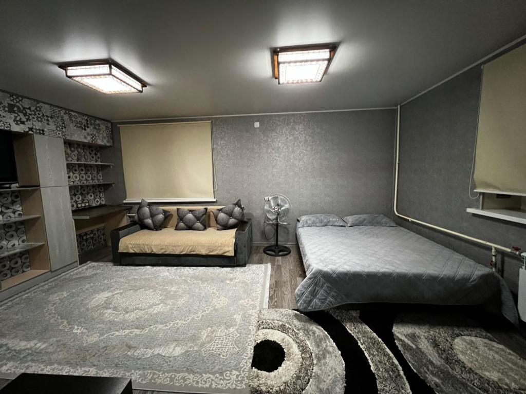 1 dormitorio con 2 camas y 1 dormitorio con alfombra en Ахметова 12 en Almaty