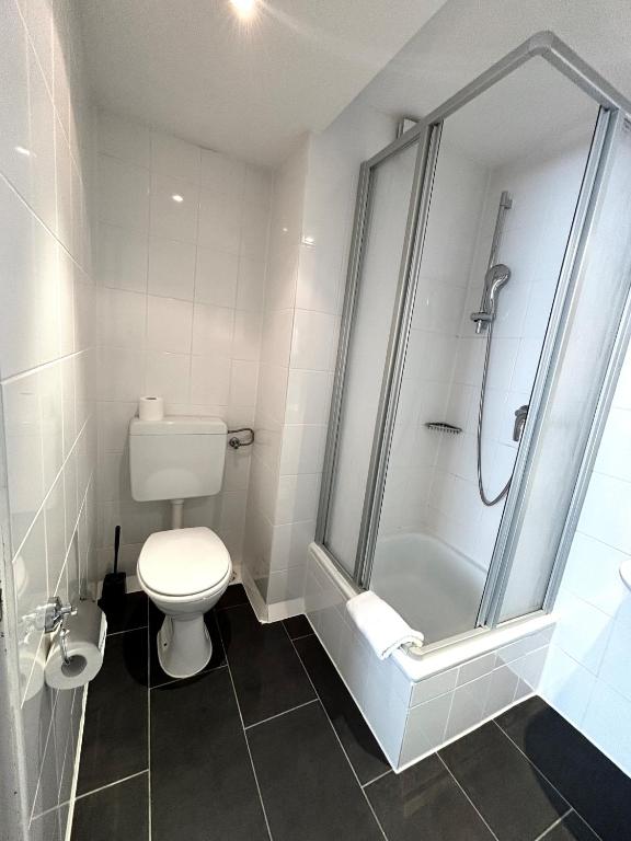 a bathroom with a white toilet and a shower at Hotel Lux in Munich