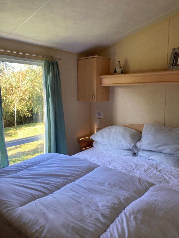 a bedroom with two beds and a window at Chans Van in Chapel Saint Leonards