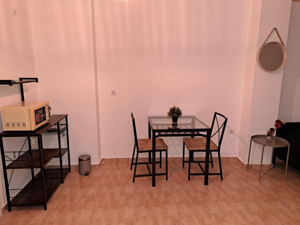 comedor con mesa, sillas y microondas en LIAM STUDIO IN SEVILLA CENTRIC, en Sevilla
