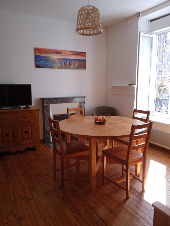 une salle à manger avec une table et des chaises en bois dans l'établissement Le Sancy, appart T2, 4 pers, centre ville du Mont Dore, à Le Mont-Dore