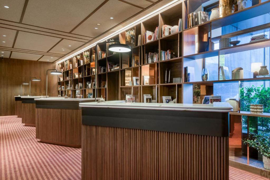 a library with a long counter and shelves of vases at AC Hotel Cuzco by Marriott in Madrid