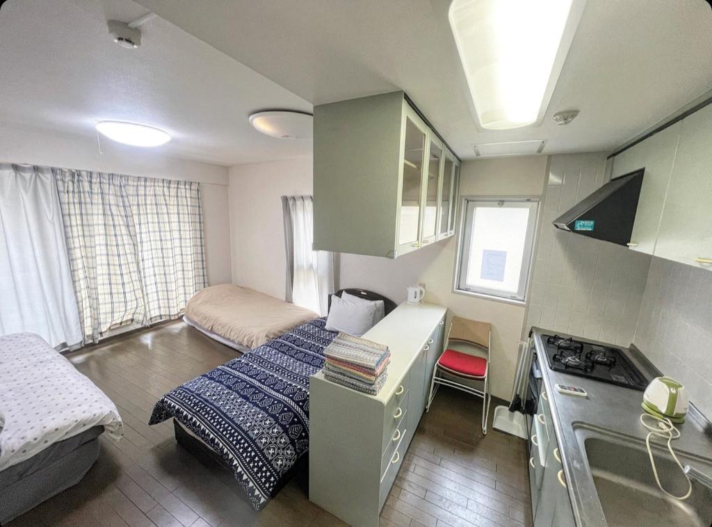 een kleine kamer met een bed en een keuken bij MATUBARA HOUSE in Tokyo