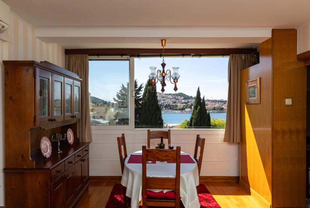 a dining room with a table and a large window at Apartments Cime in Dubrovnik