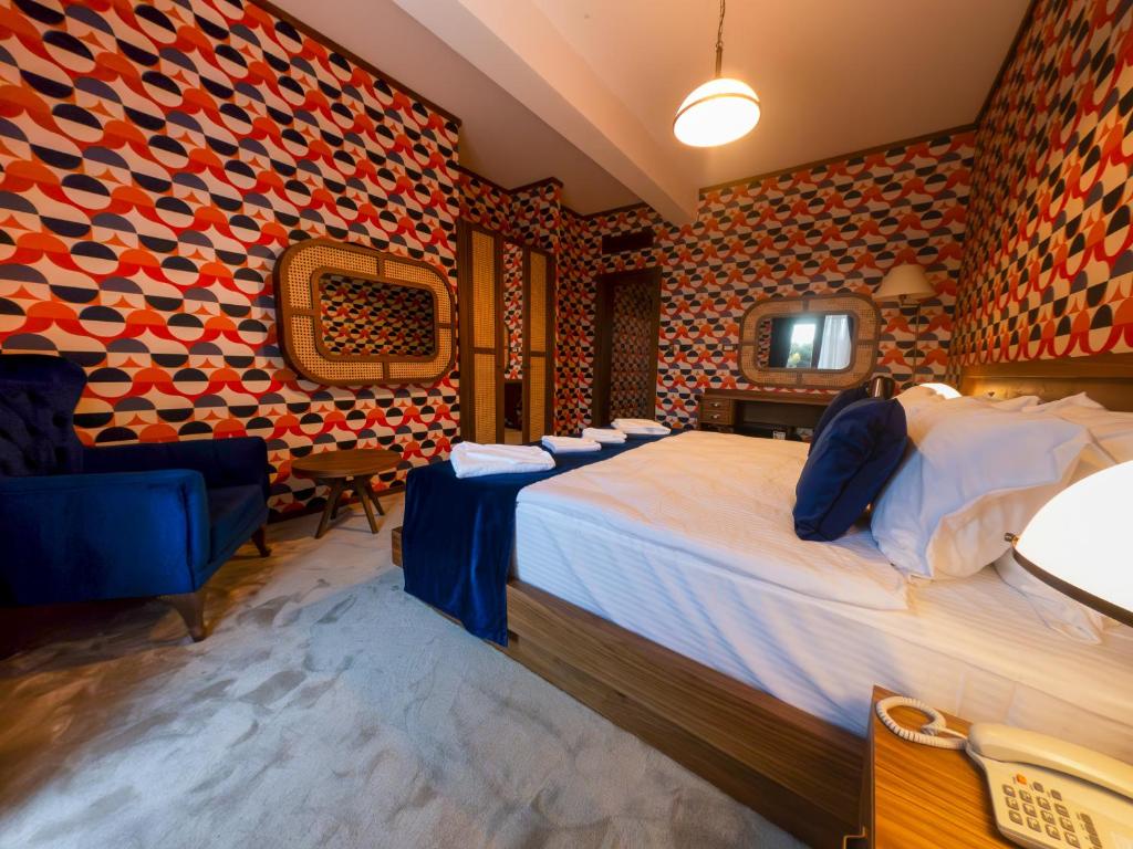 a hotel room with a large bed and a chair at 74 Museum Hotel in Antalya