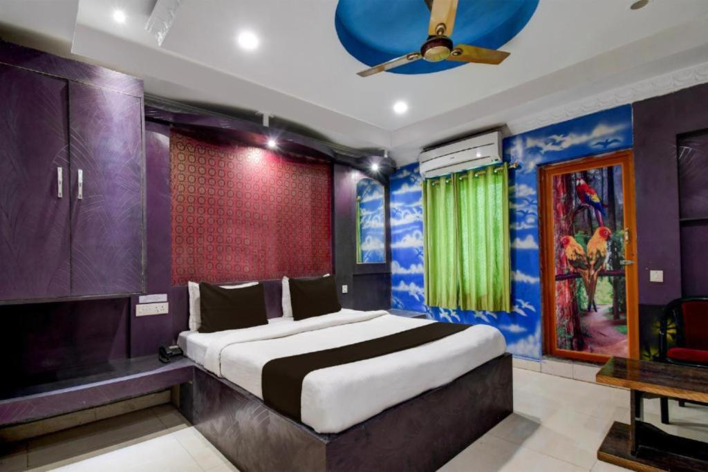 a bedroom with a large bed with purple walls and a ceiling at Goroomgo Hotel Blue Royal Swimming Pool Hotel Near DN Regalia Mall in Bhubaneshwar