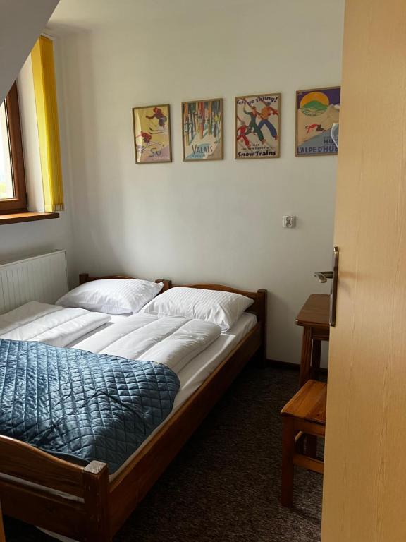 2 łóżka pojedyncze w pokoju z obrazami na ścianie w obiekcie Base Camp Pieniny w mieście Niedzica