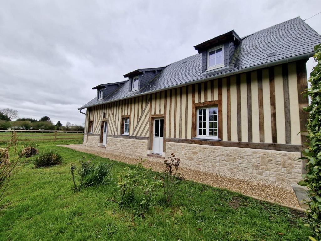 Maison normande à la campagne في Saint-Désir: حضيرة قديمة وامامها ساحة عشب