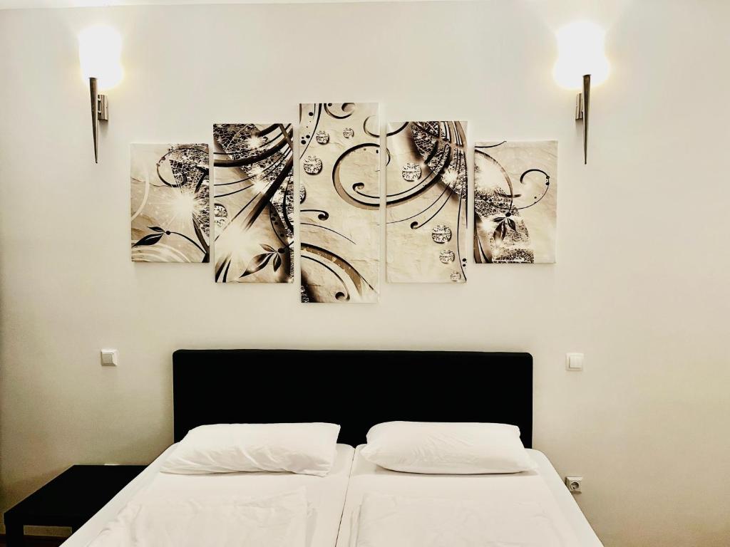 a bedroom with three paintings on the wall at Luxury Premium Furnished Apartment in Bonn