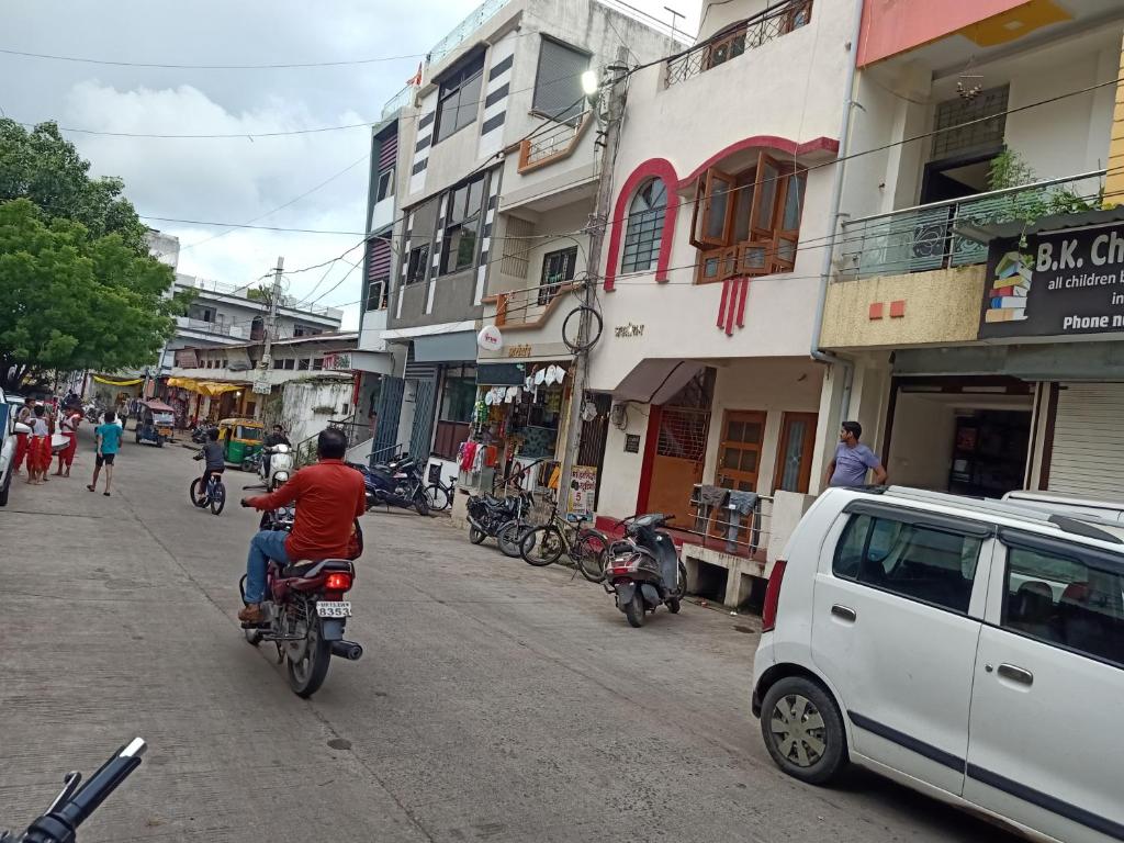 a person riding a motorcycle down a city street at Shree shiv tara guest house in Ujjain