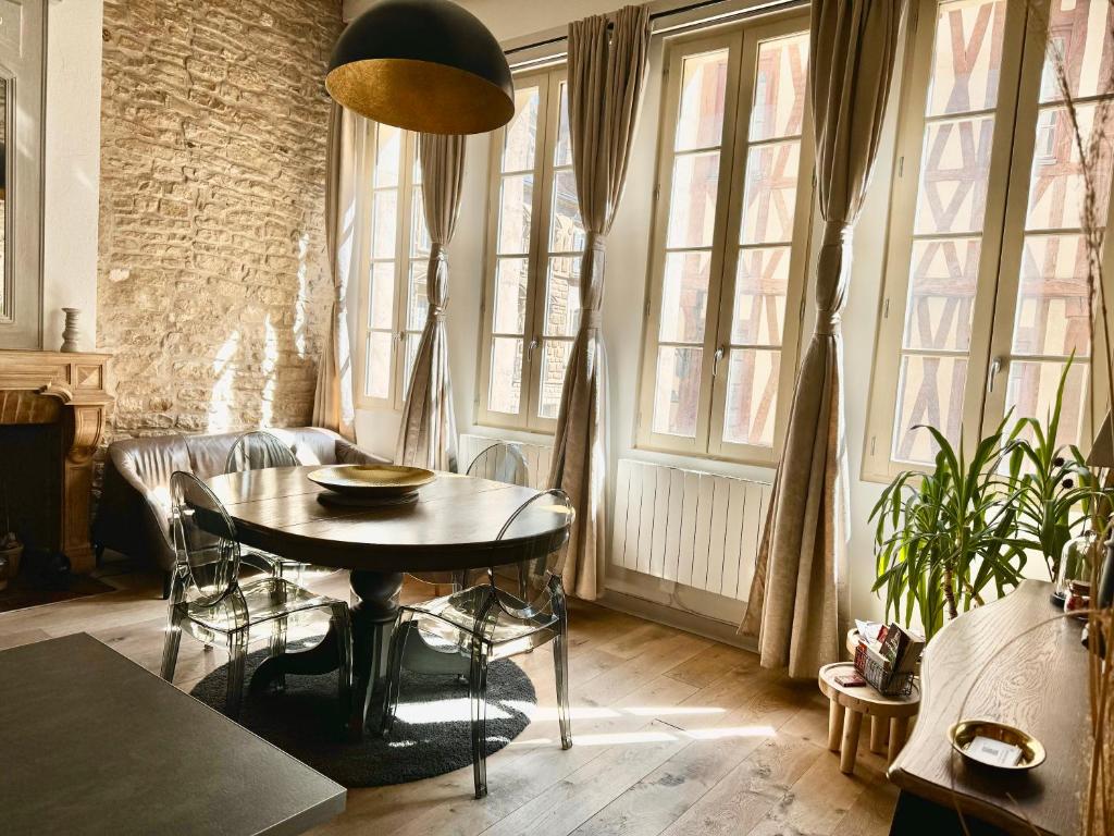 Una sala de estar con una mesa y algunas ventanas. en Centre historique de Dijon "Le Lion des Ducs" et "Le Lion des Ducs with Terrace", en Dijon