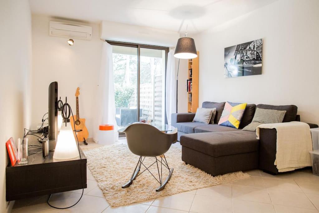 un salon avec un canapé et une chaise dans l'établissement Belle villa-patio à 700m de l'océan, à Seignosse