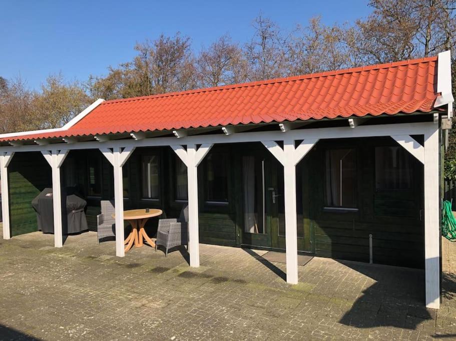 pawilon z pomarańczowym dachem i stołem w obiekcie Vakantiehuis 't Klavertje w mieście Noordwijk