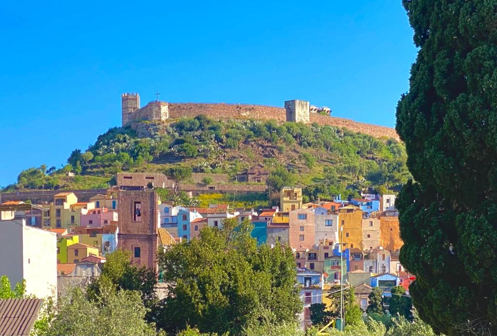 a city with a castle on top of a hill at Casa vacanza comoda con vista in Bosa