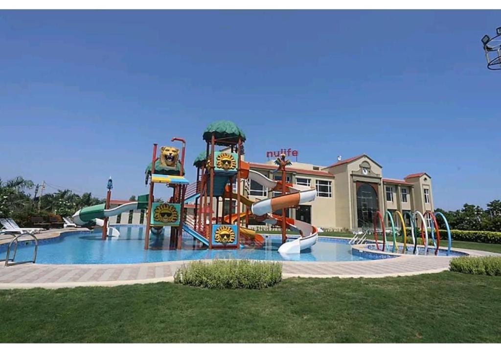 a water park with a water slide in front of a building at Nulife Resort in Jamnagar