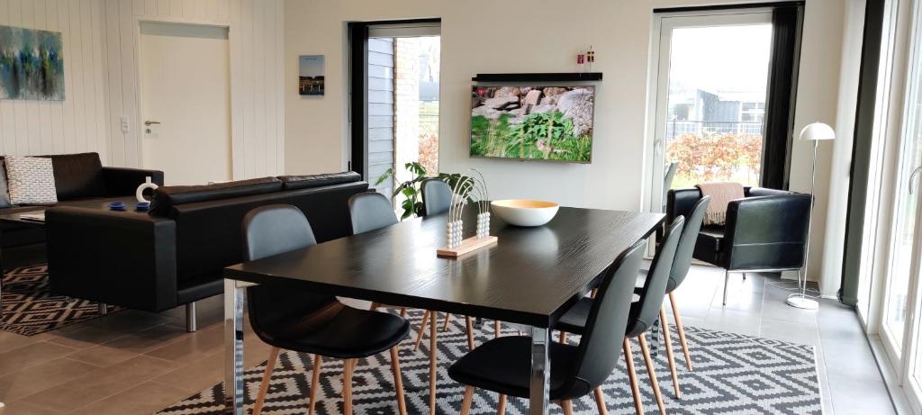 Øster Hurup的住宿－Ferie-Oasen i Øster Hurup，客厅设有餐桌和椅子
