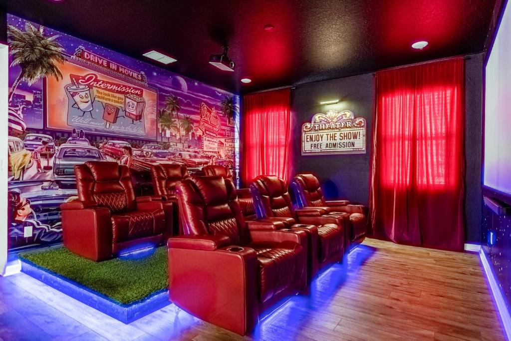 una sala de cine con sillas de cuero y un póster de cine en Family Resort - 12BR Mansion - Sleeps 28 - Private Pool, BBQ and Games Room!, en Kissimmee
