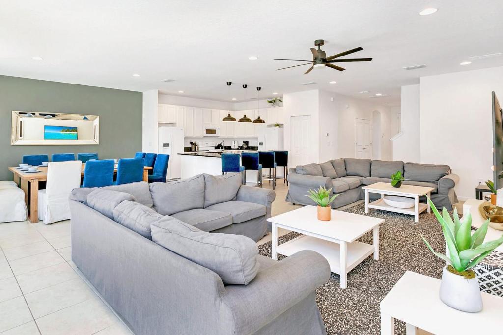 sala de estar con 2 sofás y cocina en 10BR Luxury Home Near Disney w Pool & Games Room, en Kissimmee
